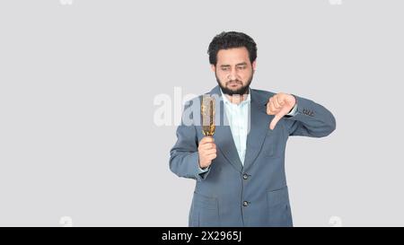 Ein kleiner Junge zeigt einen schlechten Gesichtsausdruck, als er den Maiskolben in der Hand ansieht. Er mochte es nicht, andererseits zeigte er Abneigung Stockfoto