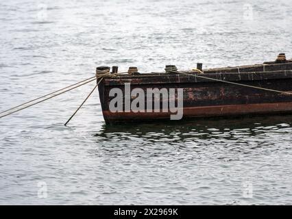 Kleines altes Holzboot, an einem sehr nebeligen Tag mit verankerten Seilen am Fuße des Douro River angedockt. Stockfoto