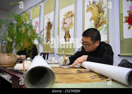 (240421) -- NANYANG, 21. April 2024 (Xinhua) -- Ein Liebhaber der Nanyang-Pyrographie macht ein Kunstwerk der Pyrographie in einer Ausbildungsklasse der Nanyang Pyrography Factory in Nanyang City, Zentralchinas Provinz Henan, 14. März 2024. Die Nanyang Pyrographie, eine traditionelle chinesische Kunst, die aus der westlichen Han-Dynastie (206 v. Chr.–25 n. Chr.) stammt, hat eine über 2.000-jährige Geschichte. Das Handwerk verwendet Werkzeuge mit hoher Temperatur, um Muster auf karbonisierbaren Materialien zu zeichnen, erzeugt visuelle Effekte, die an traditionelle chinesische Gemälde erinnern. Es wurde 2021 als immaterielles Kulturerbe auf nationaler Ebene aufgeführt. Li Zhe, 54, Stockfoto