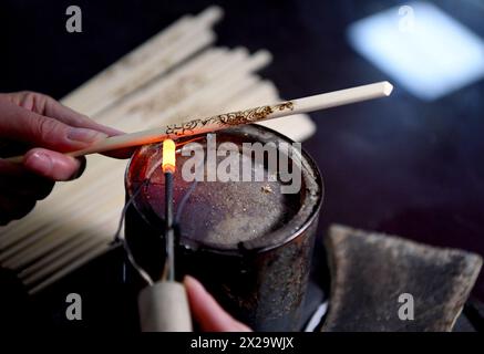 (240421) -- NANYANG, 21. April 2024 (Xinhua) -- Ein Liebhaber der Nanyang-Pyrographie macht ein Kunstwerk der Pyrographie auf einem Stäbchen in einer Trainingsklasse der Nanyang Pyrography Factory in Nanyang, Zentralchinas Provinz Henan, 14. März 2024. Die Nanyang Pyrographie, eine traditionelle chinesische Kunst, die aus der westlichen Han-Dynastie (206 v. Chr.–25 n. Chr.) stammt, hat eine über 2.000-jährige Geschichte. Das Handwerk verwendet Werkzeuge mit hoher Temperatur, um Muster auf karbonisierbaren Materialien zu zeichnen, erzeugt visuelle Effekte, die an traditionelle chinesische Gemälde erinnern. Es wurde 2021 als immaterielles Kulturerbe auf nationaler Ebene aufgeführt Stockfoto