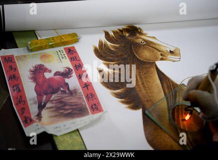 (240421) -- NANYANG, 21. April 2024 (Xinhua) -- Ein Liebhaber der Nanyang-Pyrographie macht ein Kunstwerk der Pyrographie in einer Ausbildungsklasse der Nanyang Pyrography Factory in Nanyang City, Zentralchinas Provinz Henan, 14. März 2024. Die Nanyang Pyrographie, eine traditionelle chinesische Kunst, die aus der westlichen Han-Dynastie (206 v. Chr.–25 n. Chr.) stammt, hat eine über 2.000-jährige Geschichte. Das Handwerk verwendet Werkzeuge mit hoher Temperatur, um Muster auf karbonisierbaren Materialien zu zeichnen, erzeugt visuelle Effekte, die an traditionelle chinesische Gemälde erinnern. Es wurde 2021 als immaterielles Kulturerbe auf nationaler Ebene aufgeführt. Li Zhe, 54, Stockfoto