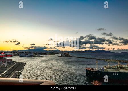 Genua, Italien - 3. Dezember 2023: Panoramablick auf den Hafen von Genua an der Mittelmeerküste am frühen Morgen. Das Frachtschiff fährt im Hafen Genua in Italien ein Stockfoto