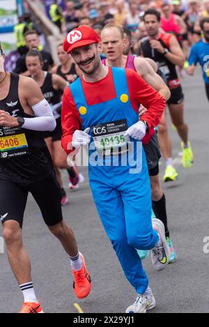 Tower Hill, London, Großbritannien. April 2024. Rund 50.000 Menschen nehmen am TCS London Marathon 2024 Teil, darunter die weltbesten Elite-Läufer und Rollstuhlsportler. Die Massen von Club- und Fun-Läufern folgen ihnen, wobei viele große Summen für wohltätige Zwecke sammeln und oft in schicken Kleidern laufen und für verschiedene Klassen Guinness-Weltrekorde anstreben. Läufer Alex Eier im Mario Kostüm Stockfoto