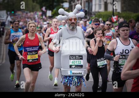 London, Großbritannien. April 2024. Marcus Mumford, 45, aus Worcester, verkleidet wie ein riesiger Wasserhahn, läuft für eine wohltätige Wasserhilfe. Der London Marathon führt die Evelyn Street in Deptford in South East London hinunter, die 13 km lange Strecke der 26,2 km langen Strecke, auf der Läufer von Einheimischen begrüßt und angefeuert werden. Guy Corbishley/Alamy Live News Stockfoto