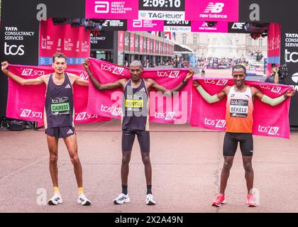 London, Großbritannien. April 2024. Die Sieger der Männer, l-t-r 3. Emile CAIRESS (GBR), 1. Alexander Mutiso MUNYAO (KEN), 2. Kenenisa BEKELE (ETH). Die Gewinner des Elite-Rennens kommen durch die Ziellinie und den Präsentationsbereich. Die Marathonroute 2024 TCS London führt von Greenwich durch die City of London und endet in der Mall in Westminster. Insgesamt werden in diesem Jahr rund 50.000 Teilnehmer erwartet, darunter 20 Abgeordnete, mehrere Peers und viele Prominente, mehrere Peers und viele Prominente. Quelle: Imageplotter/Alamy Live News Stockfoto