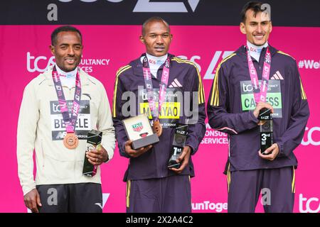 London, Großbritannien. April 2024. Die Sieger der Männer, l-t-r, 2. Kenenisa BEKELE (ETH), 1. Alexander Mutiso MUNYAO (KEN), 3. Emile CAIRESS (GBR). Die Gewinner des Elite-Rennens kommen durch die Ziellinie und den Präsentationsbereich. Die Marathonroute 2024 TCS London führt von Greenwich durch die City of London und endet in der Mall in Westminster. Insgesamt werden in diesem Jahr rund 50.000 Teilnehmer erwartet, darunter 20 Abgeordnete, mehrere Peers und viele Prominente, mehrere Peers und viele Prominente. Quelle: Imageplotter/Alamy Live News Stockfoto