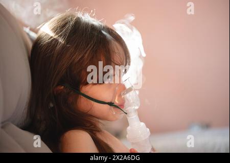 Thema der Atemkindinhalationstherapie. Profilporträt des Mädchens mit medizinischer Maske Stockfoto