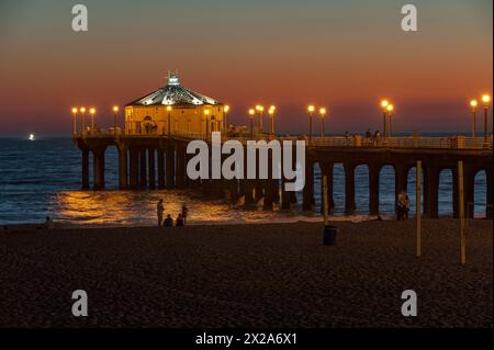 Die Menschen genießen den Sonnenuntergang am Manhattan Beach am pazifik-Küstenstrand in der South Bay-Gegend von Los Angeles, CA, USA Stockfoto