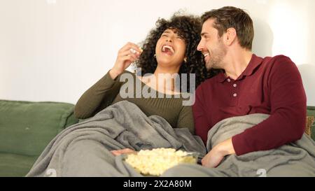 Ein Paar flirtet beim Popcorn und sieht sich zuhause einen Film an Stockfoto