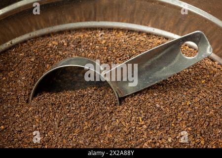 Mittelgroßer gerösteter Kaffeesatz mit einer Schaufel in einer Metalldose. Stockfoto