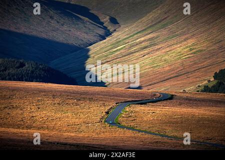 Verwinkelte einsame Straße durch Moorland mit Bergkulisse Stockfoto