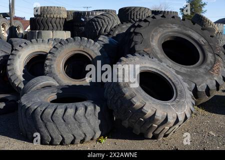 Entsorgte Traktorreifen füllen eine leere Partie in einer Reifenwerkstatt in Aberdeen, Washington. Stockfoto