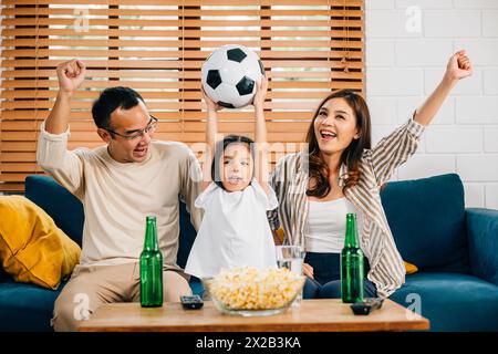 Eine glückliche Familie genießt den Nervenkitzel eines Fußballspiels zu Hause Stockfoto