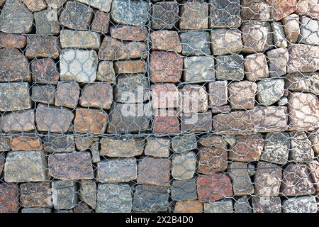 Gabion und Felsenpanzerung - Schutz vor Küste und Wasserstraßen. Gabionenwände aus Stahldrahtkorb. Stockfoto