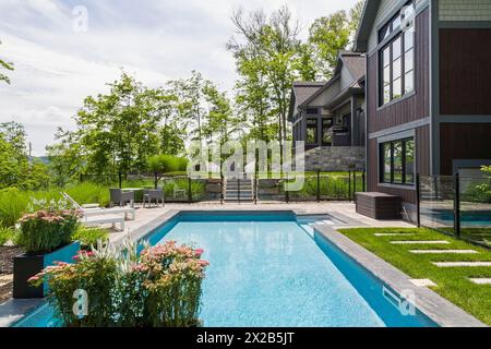 In den Boden Schwimmbad- und Rückansicht des zeitgenössischen Naturstein und braun gebeizt und Cedar Schindeln verkleidet luxuriöse Bungalow Stil home in Su Stockfoto