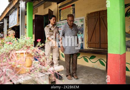 BOKAKHAT, INDIEN, 19. APRIL: Ein Sicherheitspersonal hilft einem älteren Menschen in einer Wahlstation während der ersten Phase der indischen Parlamentswahlen Stockfoto