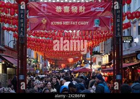 Ein chinesisches Neujahrsbanner und Touristen auf der Gerrard Street, dem Zentrum von Chinatown, einer ethnischen Enklave in Westminster, London. England Stockfoto