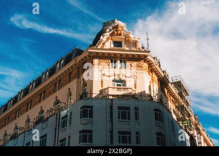 Madrid, Spanien. 2. April 2024 malerische urbane Szene. Alte Wohnhausfassade, wunderschön dekorierte Fassade vor blauem Himmel. Wunderschönes Gebäude Stockfoto