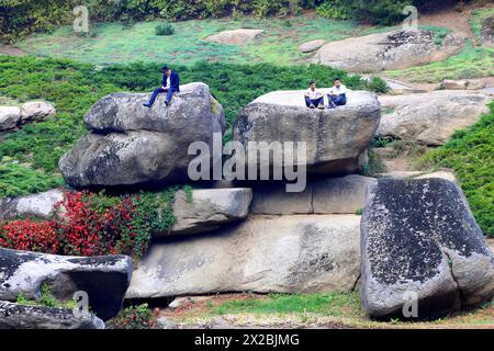 Junge chassidische Juden sitzen während des jüdischen Neujahrs auf großen Steinen im Sofia Park. Uman, Ukraine, 23. September 2017 Stockfoto