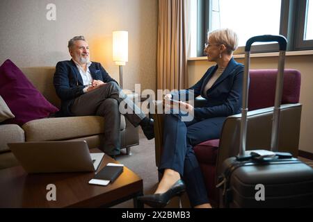 Erwachsener kaukasischer Geschäftsmann und Geschäftsfrau im Hotelzimmer Stockfoto