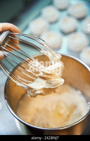 Professionelle Bäckerin, die Fruchtpüree mit anderen Zutaten schlägt Stockfoto