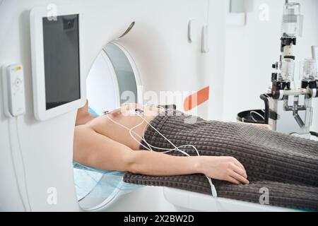 Mann im kontrastverstärkten EKG-getriggerten Koronar-CT-Verfahren Stockfoto