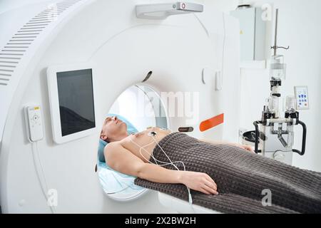 Mann im kontrastverstärkten EKG-getriggerten Koronar-CT-Verfahren Stockfoto