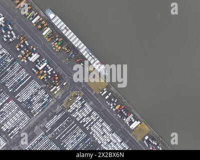 Von oben nach unten auf dem Roll-on-Roll-off-Terminal, dem Versand und der Logistik von Fahrzeugen auf der ganzen Welt. Top-Down-Ansicht auf dem angedockten und im geladenen Schiff Stockfoto