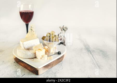 brie, Camembert, Gorganzola mit Oliven und Kirschtomaten. Weichkäse mit weiß- und Blauschimmelpilz, Oliven und Olivenöl, ein Glas Rotwein. Spa kopieren Stockfoto