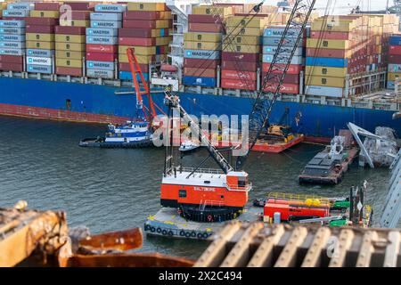 Dundalk, Vereinigte Staaten Von Amerika. April 2024. Dundalk, Vereinigte Staaten von Amerika. April 2024. Krankähne heben Wrackteile der eingestürzten Francis Scott Key Bridge vom MV Dali Containerschiff ab, während die Arbeiten zur Eröffnung des Fort McHenry Kanals am 21. April 2024 in der Nähe von Dundalk, Maryland, fortgesetzt werden. Die Brücke wurde am 26. März von einem 984-Fuß-Containerschiff getroffen und stürzte zusammen, wobei sechs Arbeiter ums Leben kamen. Quelle: PO3 Erin Cox/USA Coast Guard Photo/Alamy Live News Stockfoto