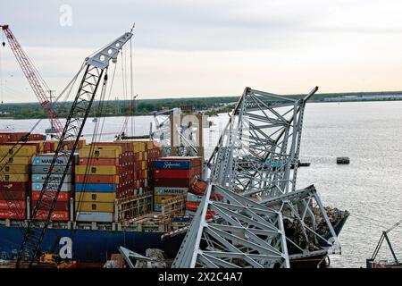 Dundalk, Vereinigte Staaten Von Amerika. April 2024. Dundalk, Vereinigte Staaten von Amerika. April 2024. Krankähne heben Wrackteile der eingestürzten Francis Scott Key Bridge und Frachtcontainer vom MV Dali Containerschiff ab, während der Bau des Fort McHenry Kanals am 21. April 2024 in der Nähe von Dundalk, Maryland, fortgesetzt wird. Die Brücke wurde am 26. März von einem 984-Fuß-Containerschiff getroffen und stürzte zusammen, wobei sechs Arbeiter ums Leben kamen. Quelle: PO3 Erin Cox/USA Coast Guard Photo/Alamy Live News Stockfoto