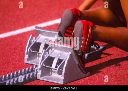 Nahaufnahme der Füße eines Sprinters bei Startblöcken auf einer Leichtathletikbahn Stockfoto