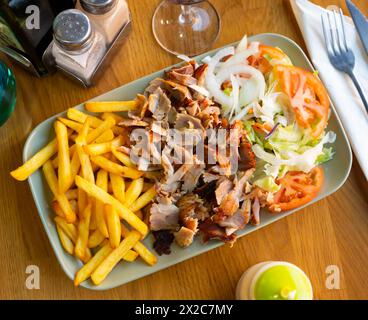Gericht mit appetitanregenden Beilagen armenischer Küche mit köstlichem Shish Kebab, pommes frites, gebackenem Gemüse, Tomaten Stockfoto