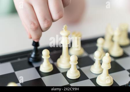 Die Hand eines Kindes hält ein Schachstück. IRA im Schach. Nahaufnahme. Ausgewählter Fokus. Hochwertige Fotos Stockfoto