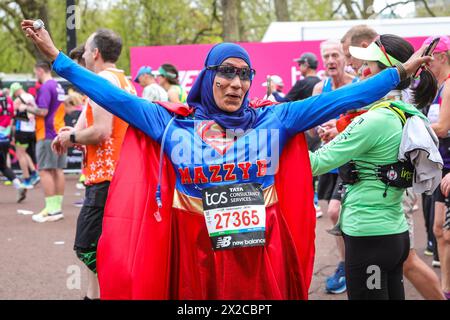 London, Großbritannien. April 2024. Läufer in den Massenrennen, darunter viele in schicken Kleidern und für Wohltätigkeitsorganisationen, an der Ziellinie. Die Marathonroute 2024 TCS London führt von Greenwich durch die City of London und endet in der Mall in Westminster. Insgesamt werden in diesem Jahr rund 50.000 Teilnehmer erwartet, darunter 20 Abgeordnete, mehrere Gleichaltrige und viele Prominente. Quelle: Imageplotter/Alamy Live News Stockfoto