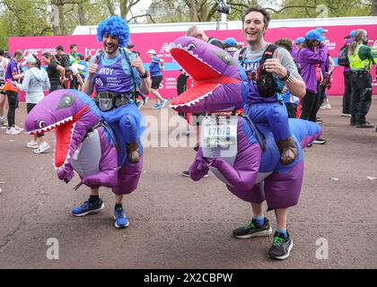 London, Großbritannien. April 2024. Läufer in den Massenrennen, darunter viele in schicken Kleidern und für Wohltätigkeitsorganisationen, an der Ziellinie. Die Marathonroute 2024 TCS London führt von Greenwich durch die City of London und endet in der Mall in Westminster. Insgesamt werden in diesem Jahr rund 50.000 Teilnehmer erwartet, darunter 20 Abgeordnete, mehrere Gleichaltrige und viele Prominente. Quelle: Imageplotter/Alamy Live News Stockfoto