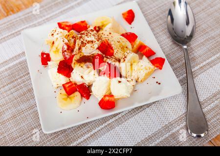 Eis mit Bananen und Erdbeeren auf dem Teller serviert Stockfoto