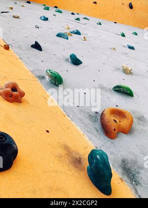 Bouldern farbenfrohe professionelle Kletterwand mit Steinen aus nächster Nähe, Sporthintergrund Stockfoto