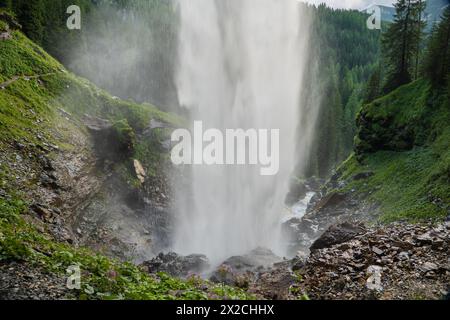 Der Wasserfall stürzt sanft die Berge hinunter. Wasser fließt sanft. Stürmischer Wasserstrom mit Tropfen und Spritzern. Stockfoto