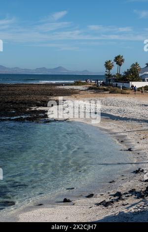 Spaziergang auf der Seepromenade in Corralejo Stadt entlang des weißen Popcorn Strandes mit weißen Korallen, schwarzen Felsen, blauem Wasser, Fuerteventura, Kanarischen Inseln, Spanien Stockfoto