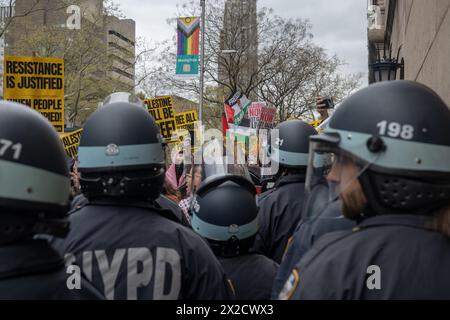 Manhattan, Usa. April 2024. NYPD-Beamte mit Aufruhrhelmen überwachen eine Gruppe pro-palästinensischer Demonstranten, die sich außerhalb der Columbia University in solidarischem Rahmen mit Studenten zusammentun, die vom NYPD für die Teilnahme an einem Campuslager auf dem South Lawn verhaftet wurden. Quelle: SOPA Images Limited/Alamy Live News Stockfoto