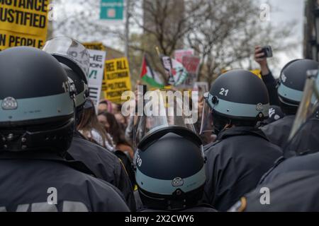 NYPD-Beamte mit Aufruhrhelmen überwachen eine Gruppe pro-palästinensischer Demonstranten, die sich außerhalb der Columbia University in solidarischem Rahmen mit Studenten zusammentun, die vom NYPD für die Teilnahme an einem Campuslager auf dem South Lawn verhaftet wurden. (Foto: Derek French / SOPA Images/SIPA USA) Stockfoto