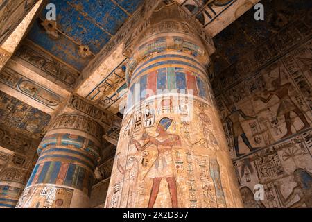 Luxor, Ägypten - 26. November 2023: Bunte Gemälde und Hieroglyphen zieren die Säulen im Tempel von Ramesses III. In Medinet Habu auf der Luxor westbank Stockfoto