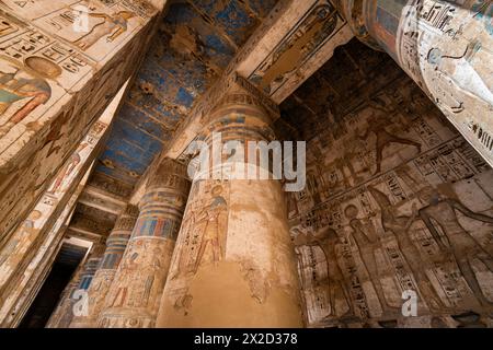 Luxor, Ägypten - 26. November 2023: Bunte Gemälde und Hieroglyphen zieren die Säulen im Tempel von Ramesses III. In Medinet Habu auf der Luxor westbank Stockfoto