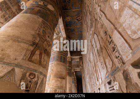 Luxor, Ägypten - 26. November 2023: Bunte Gemälde und Hieroglyphen zieren die Säulen im Tempel von Ramesses III. In Medinet Habu auf der Luxor westbank Stockfoto