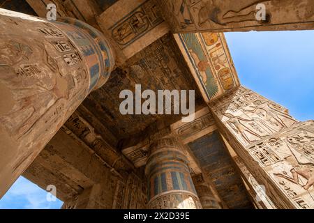 Luxor, Ägypten - 26. November 2023: Bunte Gemälde und Hieroglyphen zieren die Säulen im Tempel von Ramesses III. In Medinet Habu auf der Luxor westbank Stockfoto