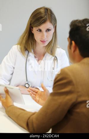 Arzt, der sich um Verkäufer kümmert, Tablet, Beratungsraum, Onkologikoa Krankenhaus, Onkologikoa Institut, Fallzentrum zur Prävention, Diagnose und Behandlung von Stockfoto