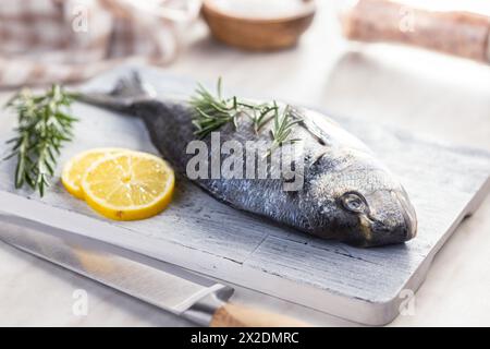 Frischer Seebrassen Fisch auf Schneidebrett auf einem Küchentisch. Stockfoto