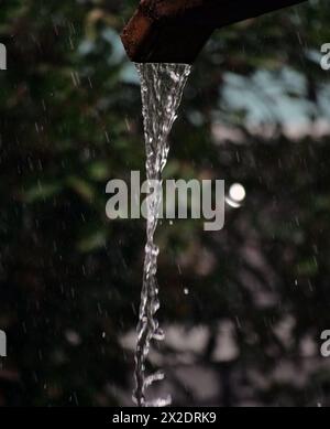 Regenwasser fließt aus der Rinne. Selektiver Fokus Stockfoto