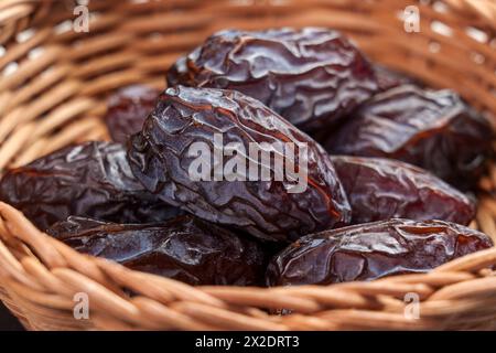 Getrocknete Medjool Datteln in hölzernen Rattanschalen Nahaufnahme. Arabisches Dessert. Ramadan traditionelles Essen. Stockfoto